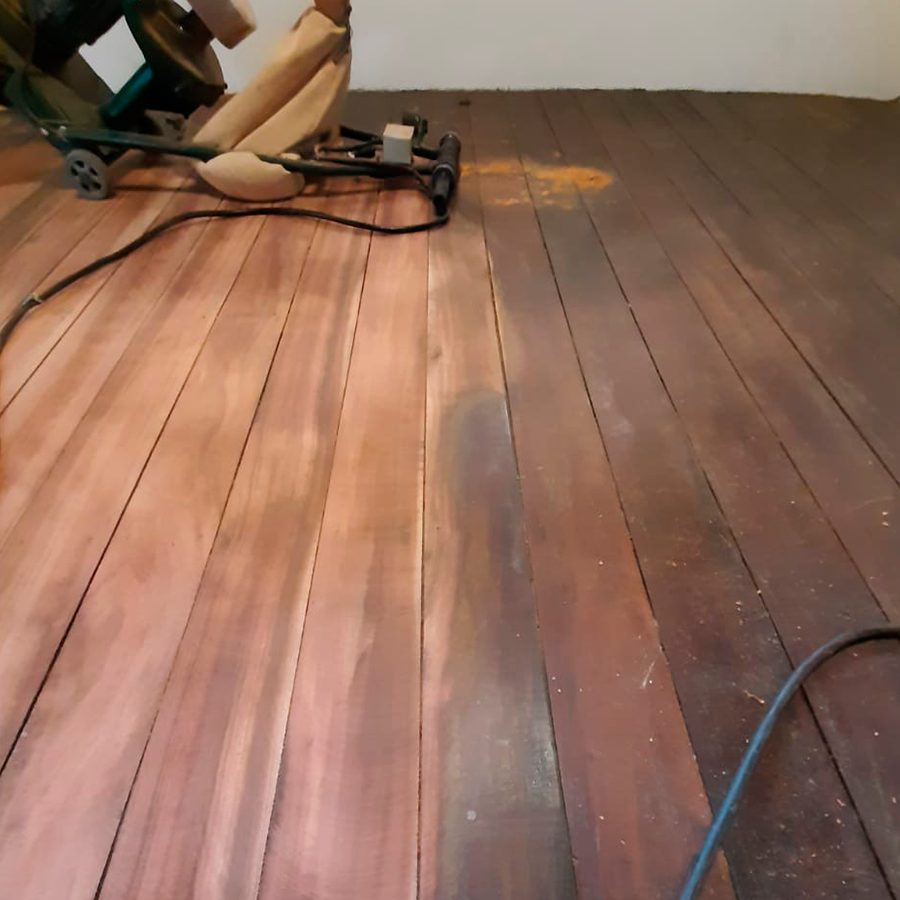 Fotografia de um piso de madeira com gordura e sujeira acumulada por conta do uso de cera.