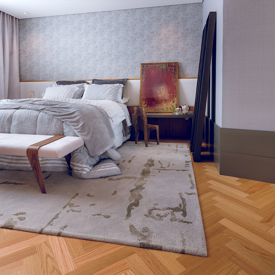 Fotografia de um quarto com piso de madeira, cama de casal, tapete cinza. banco e um quadro sobre mesa de cabeceira