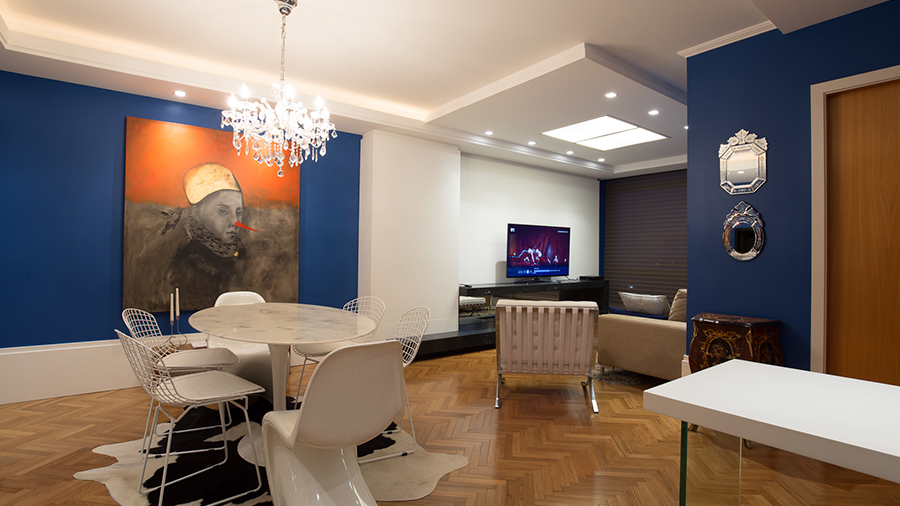 Fotografia de ambiente interno com Taco Peroba Dourada, com decoração em branco e com paredes em azul marinho.