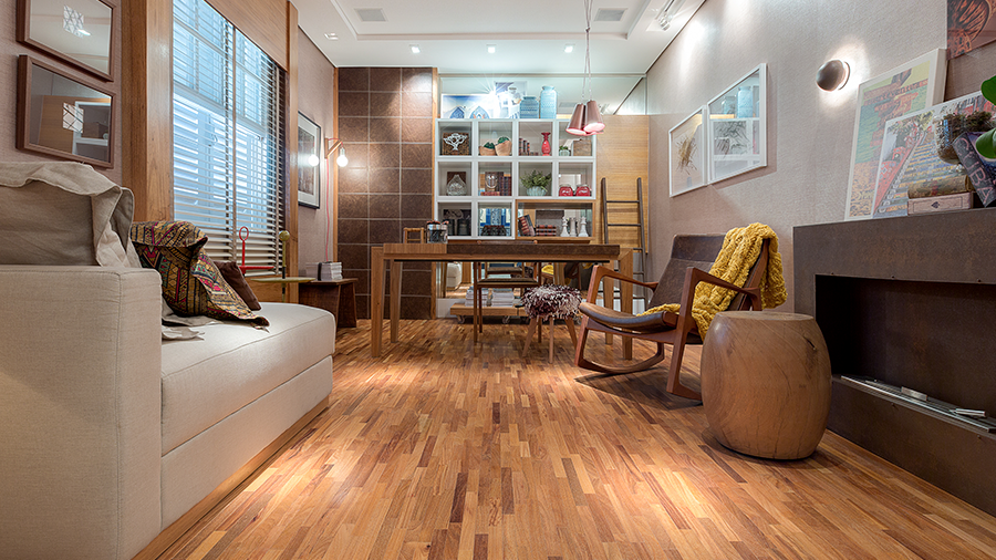 Fotografia de sala com piso de madeira e decoração bem aconchegante, com muitos itens de madeira.