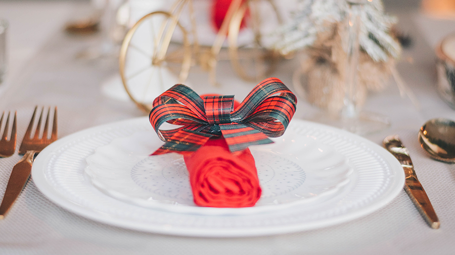 Decoração natalina simples usando um laço decorativo no guardanapo.