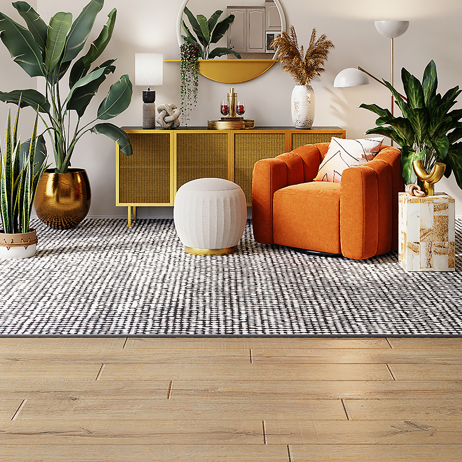 Fotografia de ambiente com piso de madeira, grande tapete e decoração com tons vivo de laranja, dourado e plantas.