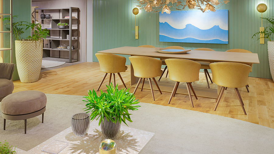 Fotografia de uma sala de jantar com paredes verdes, piso de madeira, vasos de plantas e móveis de madeira com estofados amarelos.