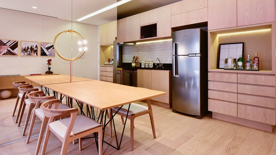 Fotografia de um ambiente integrado de cozinha e sala de jantar com piso, móveis e bancada de madeira