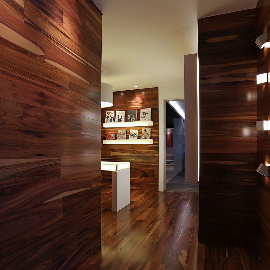 Fotografia de um ambiente interno com piso e paredes de madeira escura.
