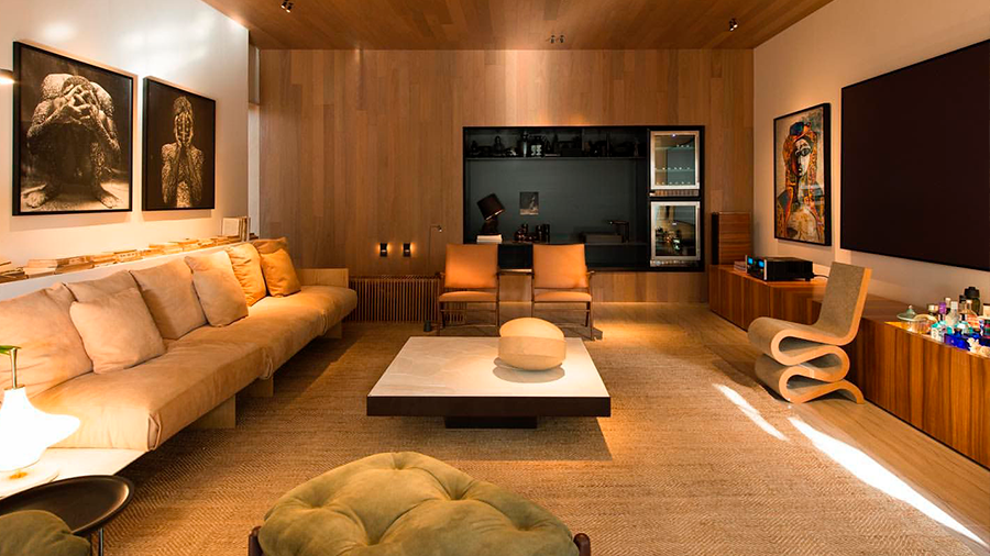 Fotografia de uma sala de estar com móveis poltrona verde, mesa de centro e diversos itens de decoração.