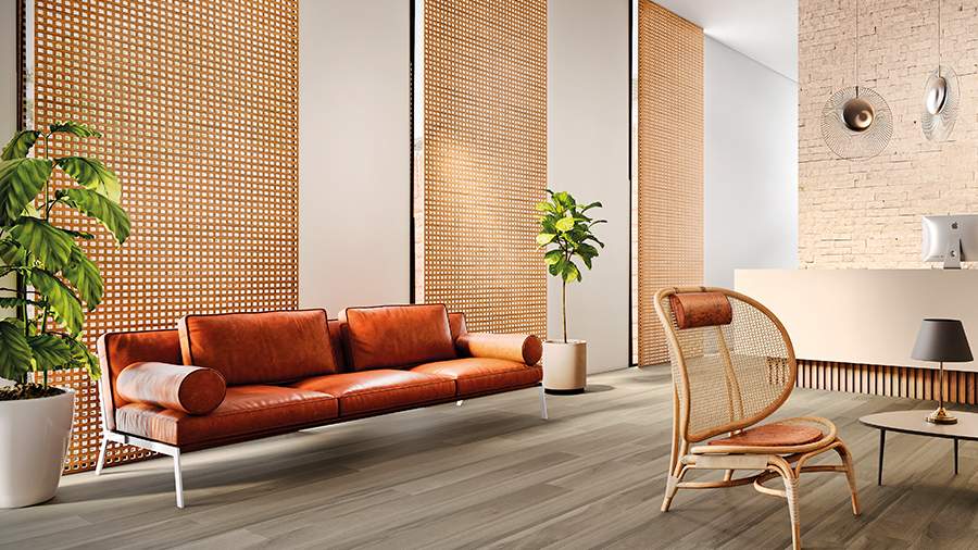 Fotografia de um espaço residencial interno com revestimento de parede com brise de madeira, piso de madeira, sofás, móveis e objetos de decoração.