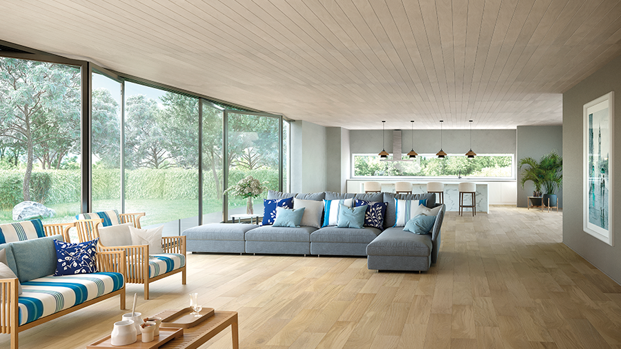 Fotografia de um espaço residencial interno com revestimento de parede e teto de madeira, piso de madeira, sofás, móveis e objetos de decoração.