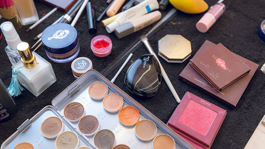 Fotografia de uma mesa com produtos de maquiagem variados.
