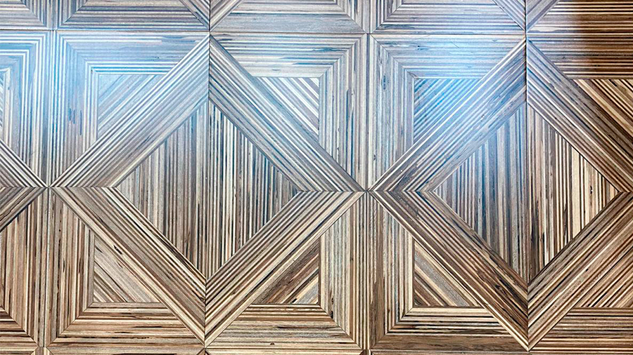 Fotografia de um piso de madeira com grafismos indìgenas.
