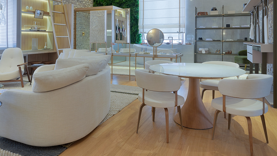Fotografia de um espaço interno integrado com piso de madeira, móveis e objetos de decoração
