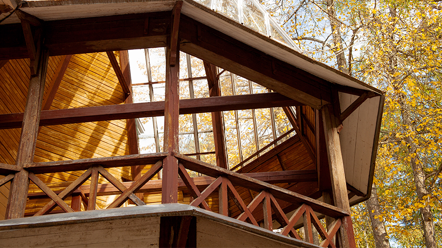 Fotografia da varanda de uma construção com estrutura de madeira.