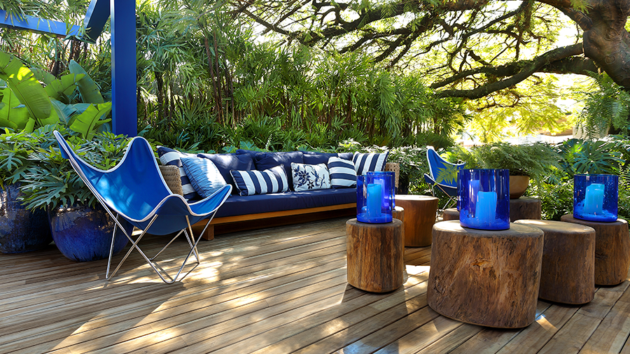 Ambiente externo com deck e decoração de madeira combinado com objetos em azul royal