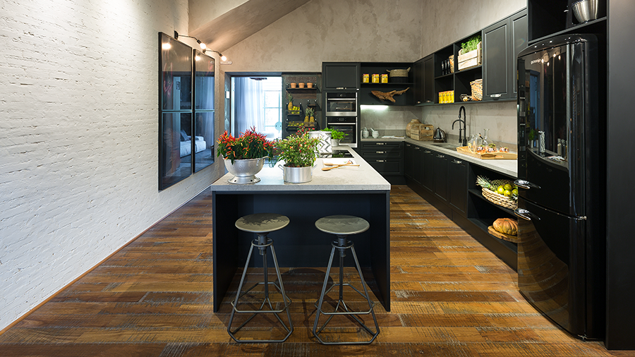Veja parede e teto em cimento queimado na cozinha, com piso de madeira.