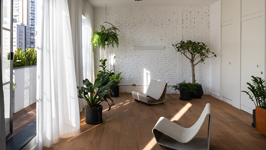 Sala de estar com piso antiquity de madeira peroba mica demolição, decoração industrial com cortinas brancas e plantas verdes na decoração do ambiente