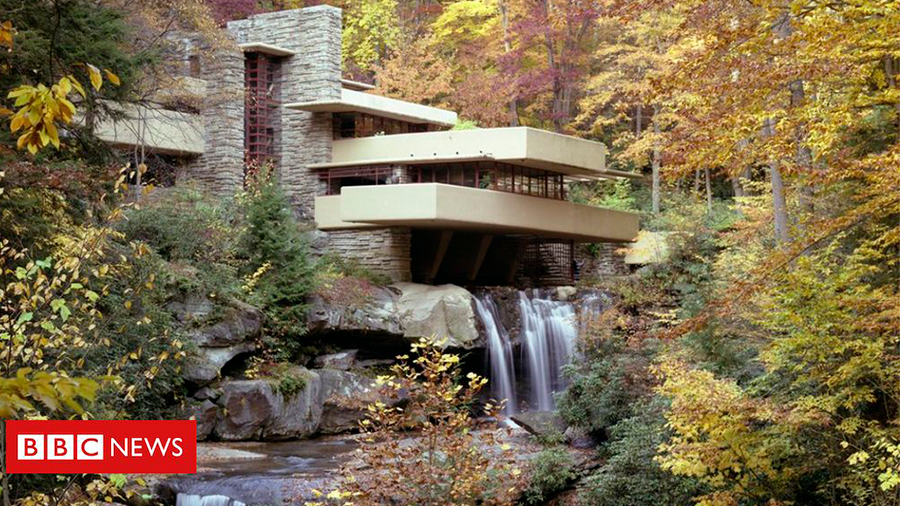 Casa de três andares, com texturas de pedra, construída sobre uma cascata, dentro de uma área verde