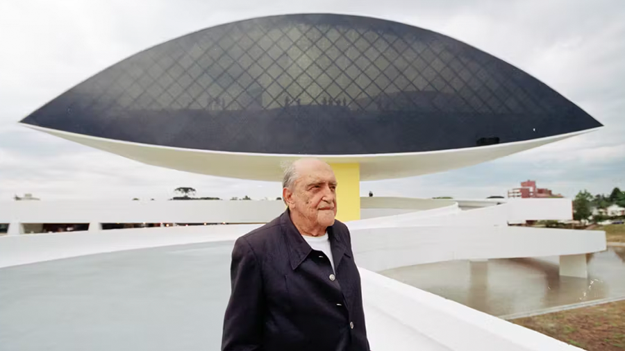 Foto de Oscar Niemeyer em frente ao museu Oscar Niemeyer em Curitiba