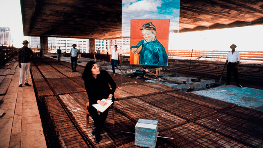 A Arquiteta Lina Bo Bardi sentada na construção do MASP, observando uma obra